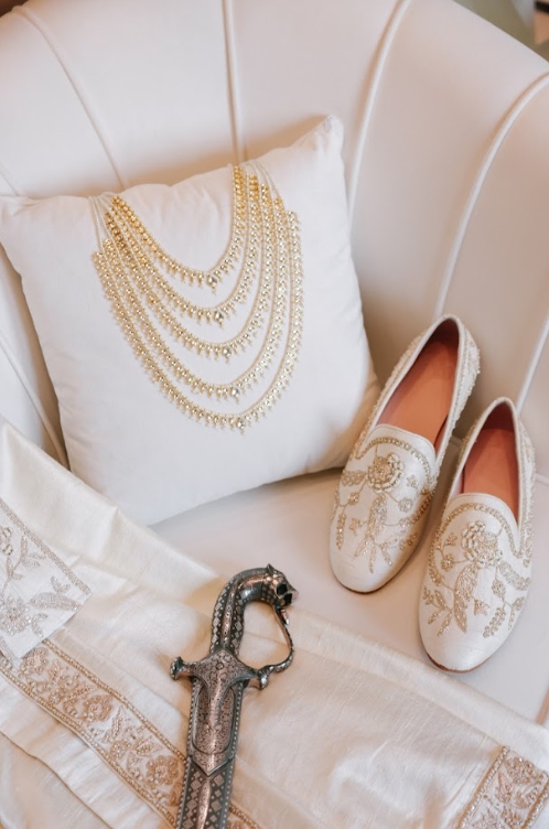 Bridal accessories including embroidered shoes, jewelry, and ceremonial sword, highlighting attire budgeting in South Asian Wedding Planning.