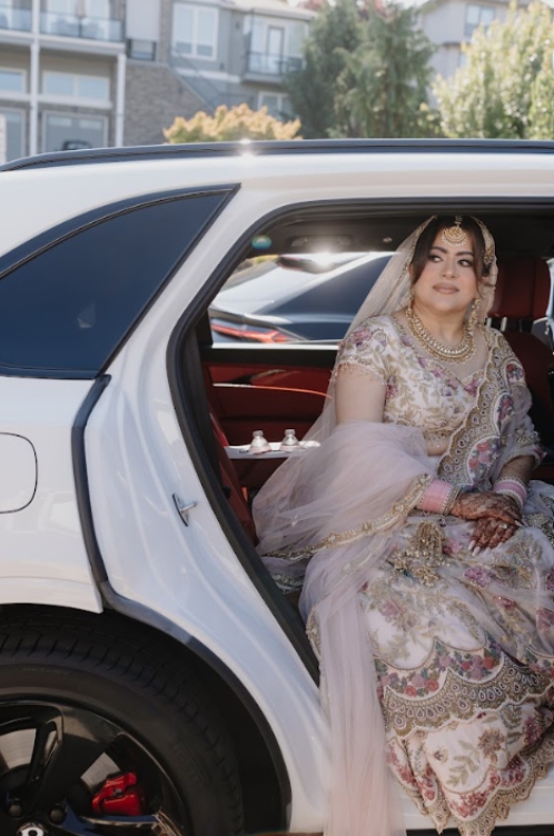 Bride arriving in a luxury vehicle during South Asian wedding traditions