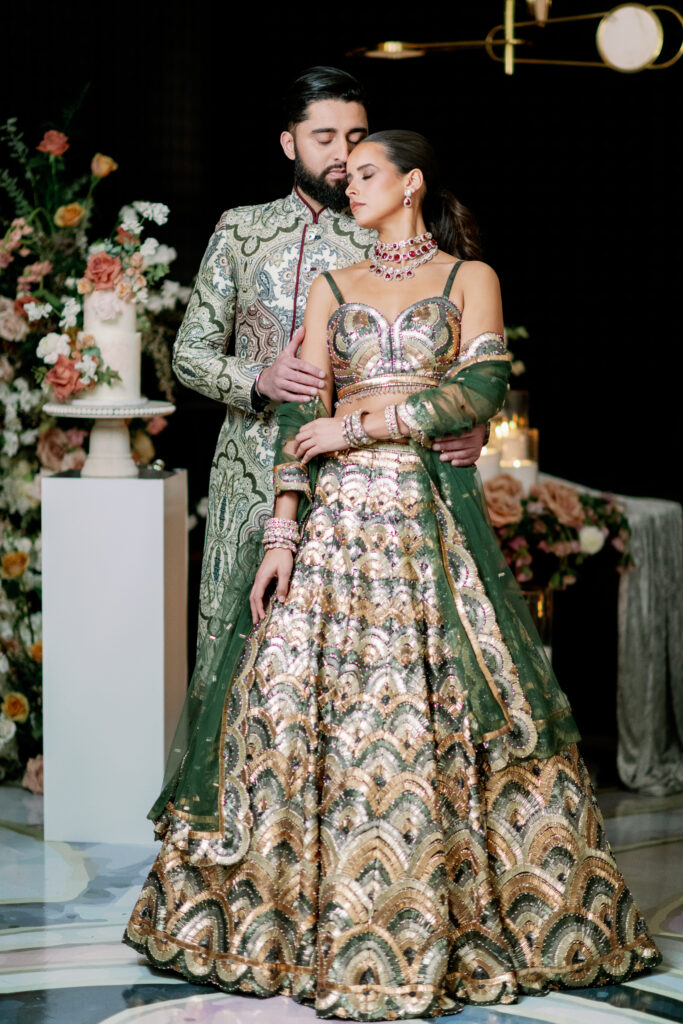 South Asian wedding couple in ornate lehenga and sherwani posing in luxury reception setting