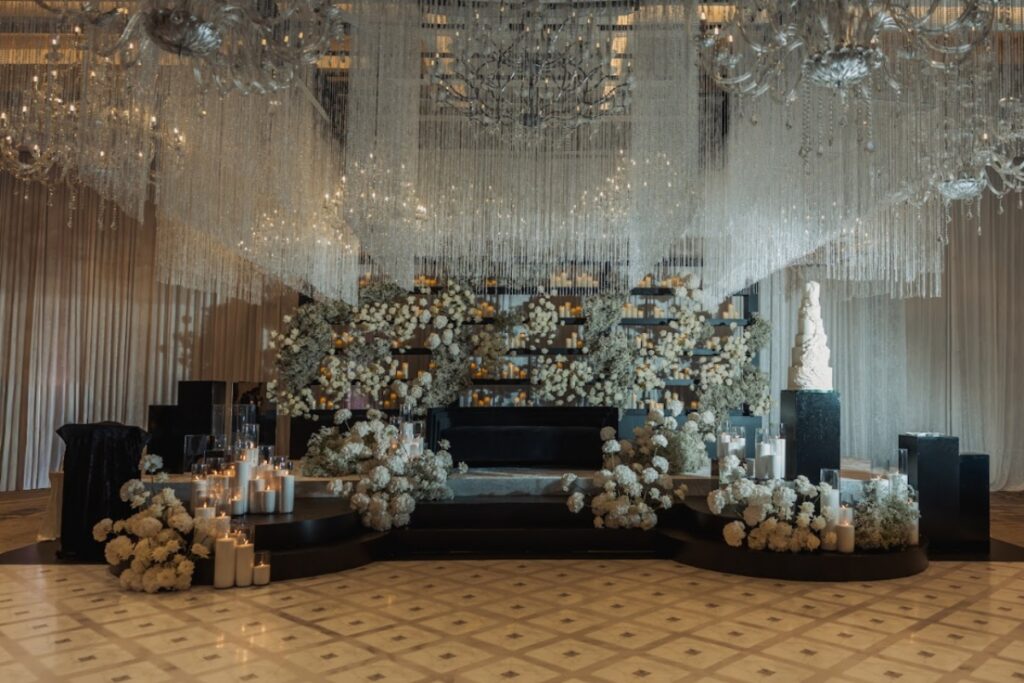 Elegant reception stage design with chandeliers and florals for luxury South Asian wedding planning inspiration