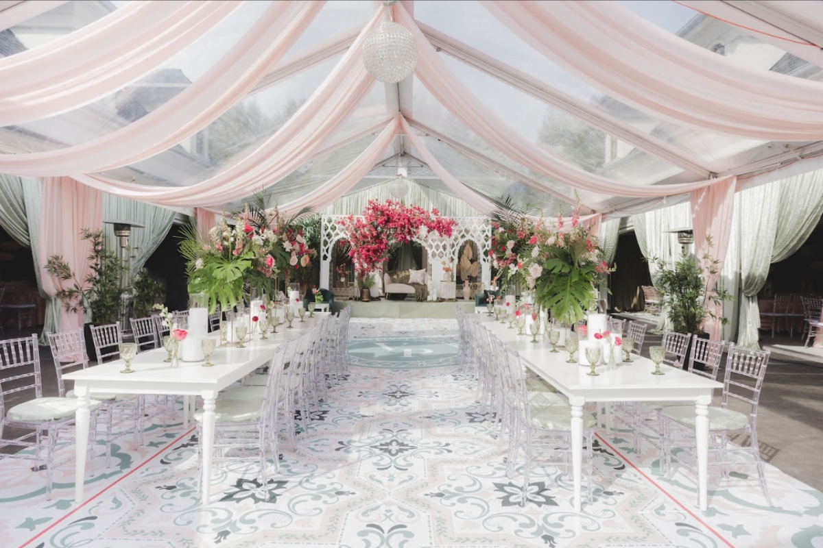 Luxury outdoor setup for South Asian wedding planning featuring floral tablescape and draped tent reception design